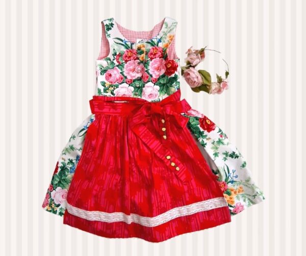 Kinderdirndl nähen mit Schnittmuster Herzilein: florales Dirndl mit Knopfleiste und roter Schürze.