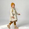 Kind trägt Mantel Ninette – Schnittmuster Kindermantel mit Ballonärmel und Kragen, genäht aus cremefarbenem Walkstoff, TOSCAminni