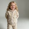 Detailansicht der Kinderjacke Dotta in Beige mit Fokus auf die lockere Passform.