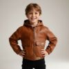 Schnittmuster Kinderjacke Dotta genäht aus braunem Kunstleder, getragen von einem lächelnden Kind
